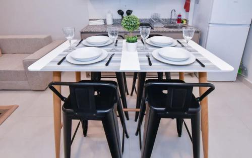 a dining room table with two black chairs and white plates at Comfy Apt w Pool & Coworking in Fernando de la Mora