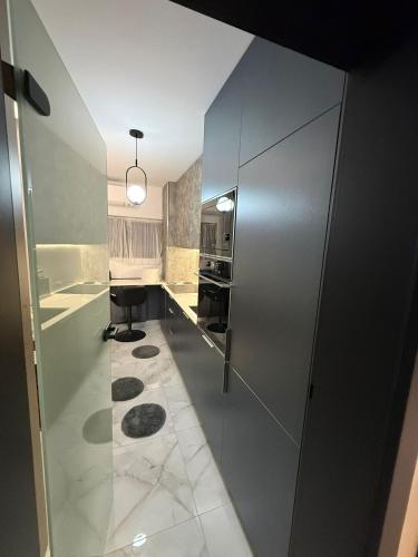 a kitchen with a large glass door with a counter at Apartament André in Sibiu