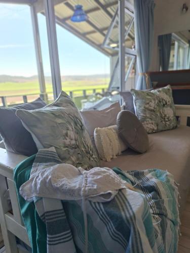 a bed with pillows on it in a room with a window at Reebok Rest in Reebok