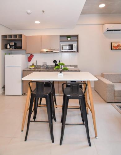 a kitchen with a white table and four stools at Cozy 1BR Desk Pool & Terrace in Fernando de la Mora