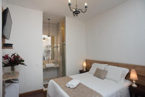 a bedroom with a bed and a bathroom with a sink at Pousada da Bia in Tiradentes