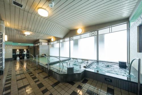 a hot tub in a large room with a large window at Hotel Monterey La Soeur Osaka in Osaka