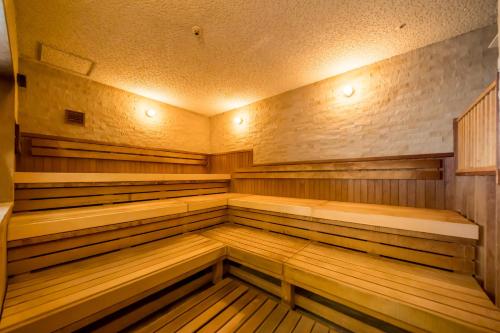 an empty sauna with wooden benches and lights at Hotel Monterey La Soeur Osaka in Osaka