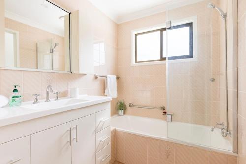 a bathroom with a tub and a sink and a shower at Callala On King - Pet Friendly - Swimming Pool in Callala Beach