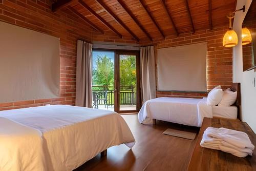 a bedroom with two beds and a large window at Unique Guatapé in Guatapé