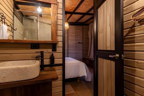 a bathroom with a sink and a bed in a room at Unique Guatapé in Guatapé