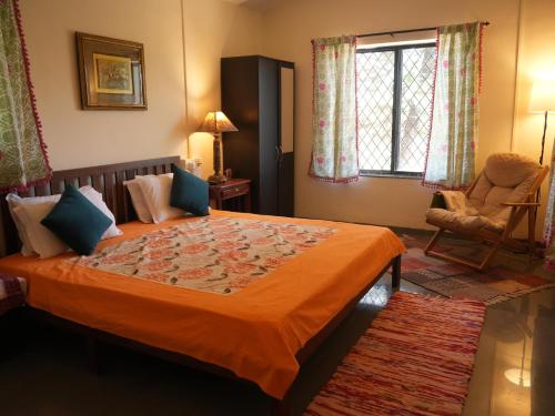a bedroom with a bed with an orange blanket at Alhaad valley views in Mulshi