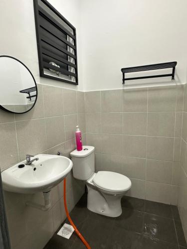 a bathroom with a sink and a toilet and a mirror at Khaeel Homestay in Ipoh