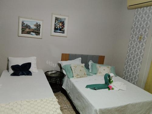 two beds with stuffed animals sitting on them in a room at Quartos da Cida in Foz do Iguaçu