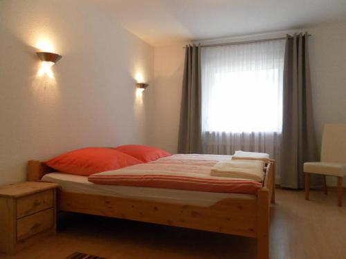 a bedroom with a bed with red pillows and a window at Burgblick Rech - Ahrtal in Rech
