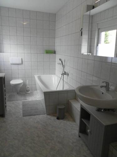 a bathroom with a tub and a sink and a toilet at Burgblick Rech - Ahrtal in Rech