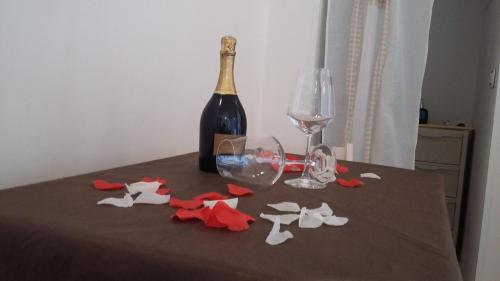 a bottle of wine and wine glasses on a table at Dimora Dei Gelsi in Polignano a Mare