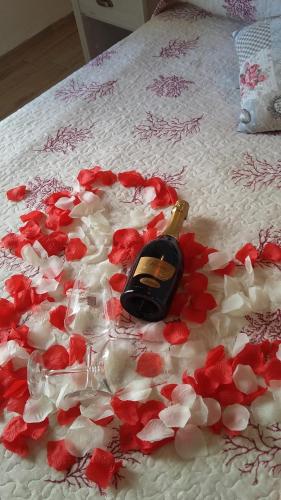 a bottle of champagne laying on a bed covered in flowers at Dimora Dei Gelsi in Polignano a Mare