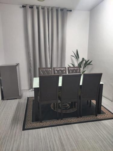 a dining room with a table and eight chairs at SHA HOMESTAY Budget in Tampin