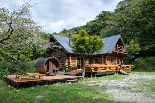 a log cabin with a wooden deck and a tree at AWA -AWA WELLNESS AREA- - Vacation STAY 63317v in Minamiboso