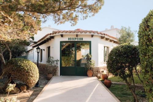 a house with a green door in front of it at BLUESEA Lentiscos in Cala en Blanes