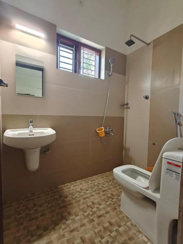 a bathroom with a sink and a toilet at Pratheeksha Homestay in Kannur