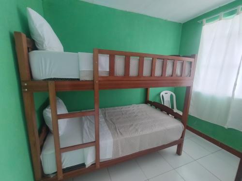 two bunk beds in a room with a green wall at Curuwasi in Moyobamba