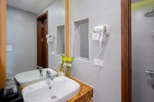 a bathroom with a sink and a phone on the wall at Amelia Sầm Sơn Boutique Holtel in Sầm Sơn