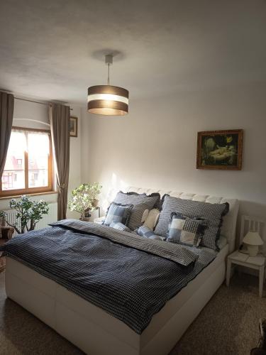 a bedroom with a large bed with a blue comforter at Diviš73 in Loket