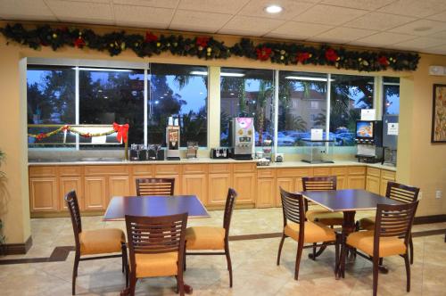 a restaurant with two tables and chairs and windows at Ontario Airport Inn in Ontario