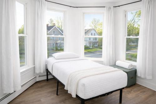 a bed in a room with two windows at Game Room Fun Extended Stay Friendly in Danielson