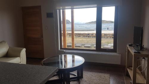 a living room with a window with a view of the ocean at Costanera Apart in Chile Chico