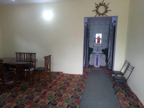 a hallway with a table and chairs and a clock on the wall at Bhaderwah Valley Resort in Bhadarwāh