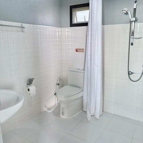 a white bathroom with a toilet and a shower at Phu Man Mhok Khao Yai in Ban Nong Takhain