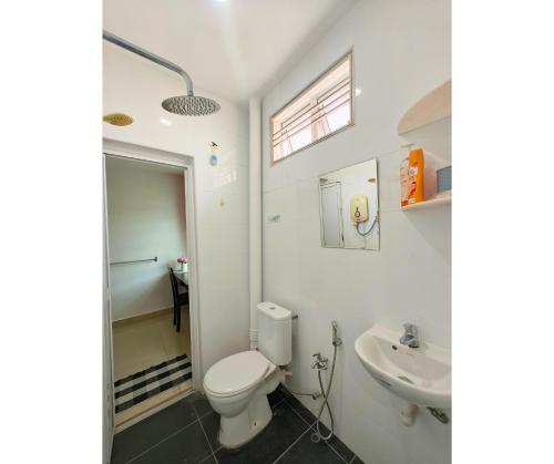 a bathroom with a toilet and a sink at 61 StayAtHome in Nibung Tebal