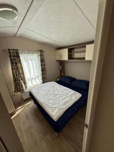 a small bedroom with a bed and a window at Chalet Vida in Petten