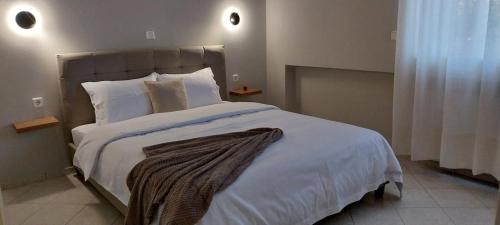 a bedroom with a large bed with white sheets and pillows at "Alsos View" in Agrinio