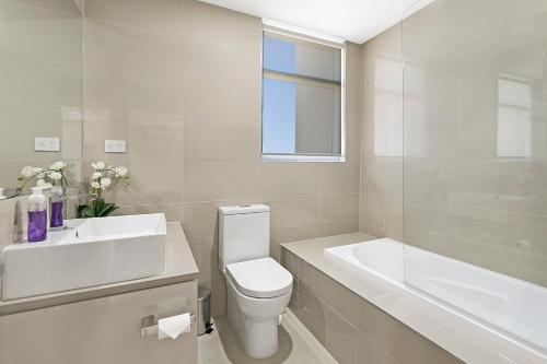 een witte badkamer met een wastafel, een toilet en een bad bij Salt 15 Luxury Apartment in Sorrento