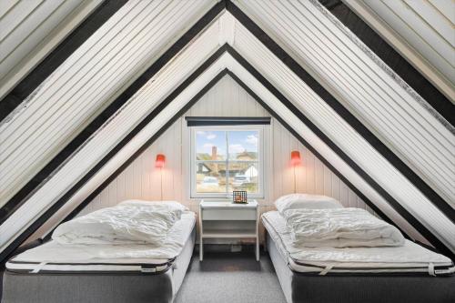 a bedroom with two beds and a window at 274-Ringkobing-Nordso-Ferievej-86 in Nørre Lyngvig