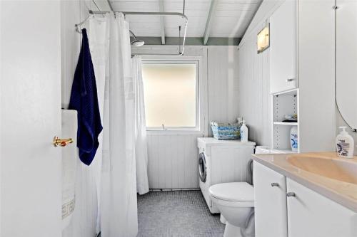 a white bathroom with a toilet and a window at FY298-Faaborg-Dybskrog-12 in Faaborg