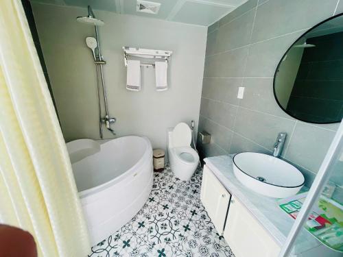a bathroom with a tub and a toilet and a sink at Villa 184 HABOBAY in Ha Long