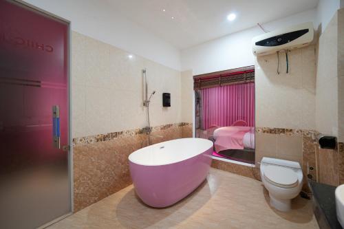 a bathroom with a tub and a toilet and a sink at Chiic House Hải Phòng in Lực Hánh
