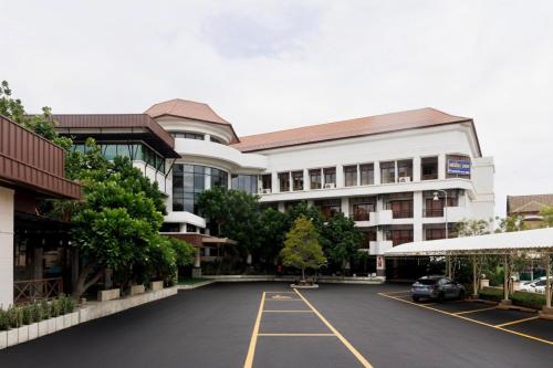 a large building with a parking lot in front of it at Central Place Hotel in Samut Sakhon