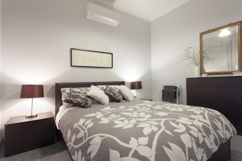 a bedroom with a bed and a dresser and a mirror at Rawson's Retreat - Five Bedroom Home - Walk CBD - Includes Breakfast in Tamworth