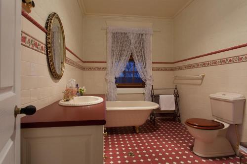 La salle de bains est pourvue d'une baignoire, de toilettes et d'un lavabo. dans l'établissement Rawson's Retreat - Five Bedroom Home - Walk CBD - Includes Breakfast, à Tamworth