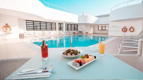 a bowl of fruit on a table next to a pool at Holiday Inn Abu Dhabi by IHG in Abu Dhabi