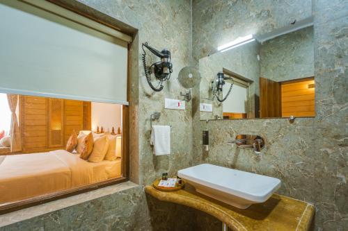 a bathroom with a bed and a sink and a mirror at Hotel Golden Haveli in Jaisalmer