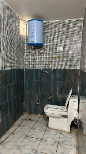 a bathroom with a toilet and a blue box on the wall at Hotel Grand Shiva in Gupta Kāshi