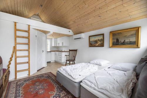 a bedroom with a bed and a ladder and a kitchen at 1616-Frederiksvaerk-Skovbrynet-7 in Frederiksværk