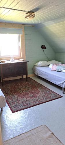 a room with two beds and a desk and a window at Welcome to Lillstugan in Jämshög