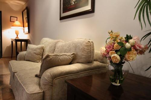 a living room with a couch and a vase of flowers on a table at Hotel Poza Rica Centro in Poza Rica de Hidalgo
