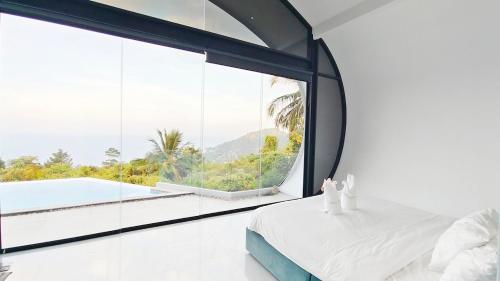 a bedroom with a large window overlooking a pool at Villa Lumina, Koh Samui in Chaweng Noi Beach