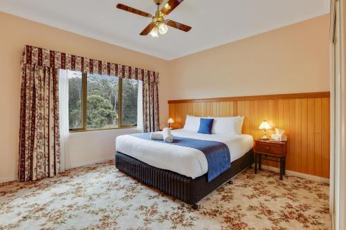 a bedroom with a large bed and a window at Robyn's Nest Lakeside Resort in Merimbula