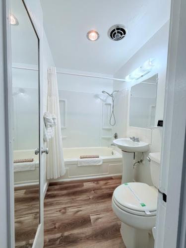 a bathroom with a toilet and a sink and a tub at John Day Motel in John Day