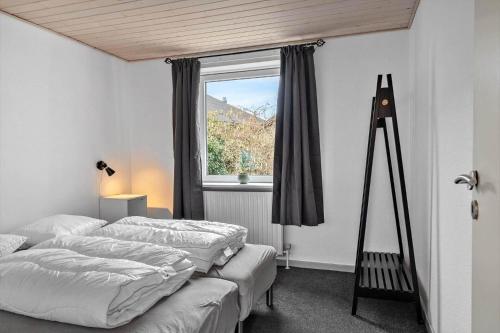 a bedroom with two beds and a window at LF10243-Thyholm-Krumborgvej-3 in Hvidbjerg